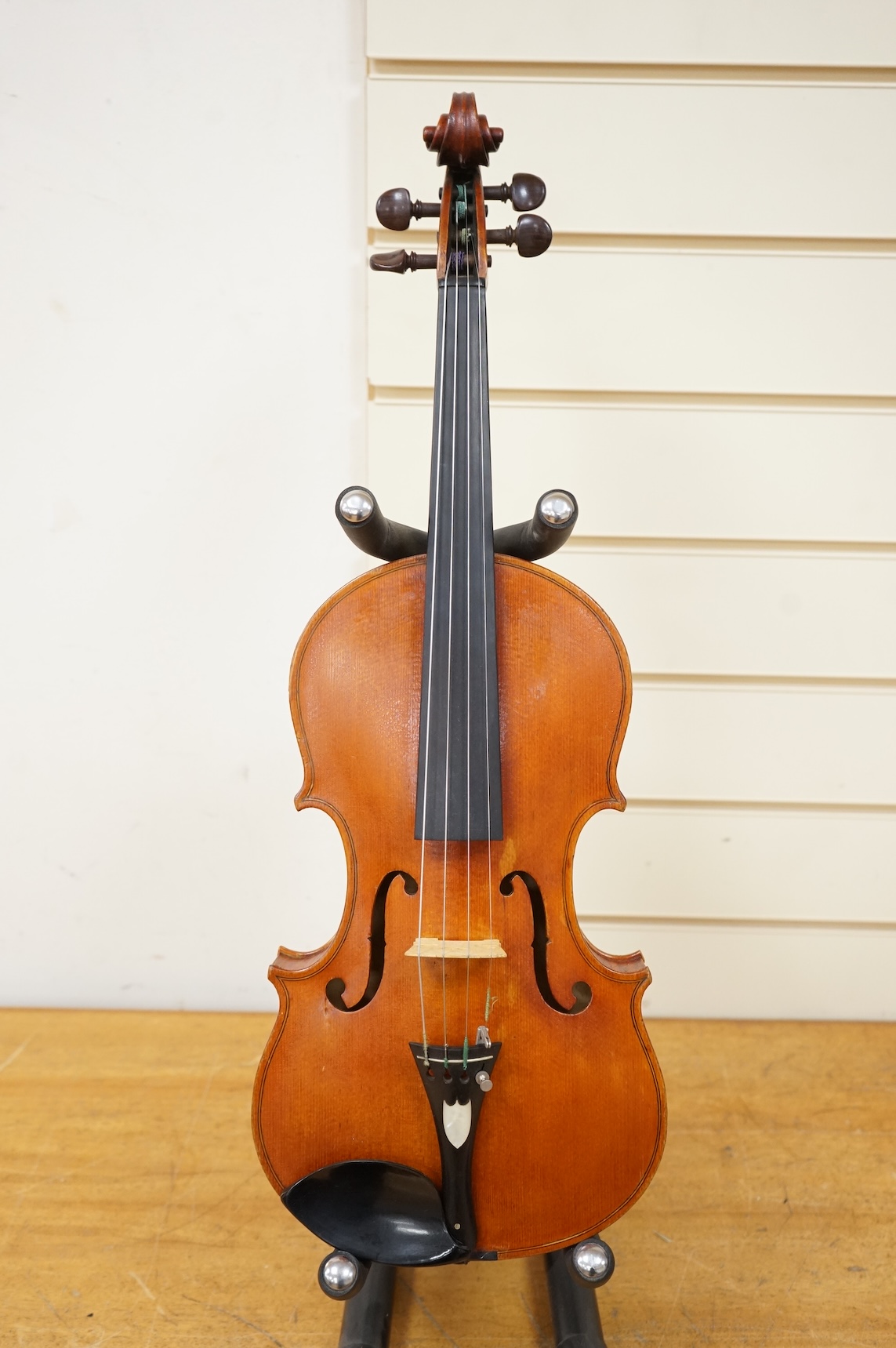 Three violins; a late 19th century German Stradivarius pattern violin, without label, a handmade violin (a.f.), with sound post crack, broken and repaired scroll, etc. and a Maidstone violin body, varnish stripped from t